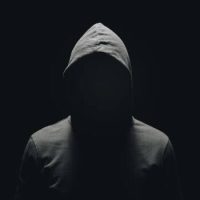 faceless man in hoodie standing isolated on black faceless man in hoodie standing isolated on black